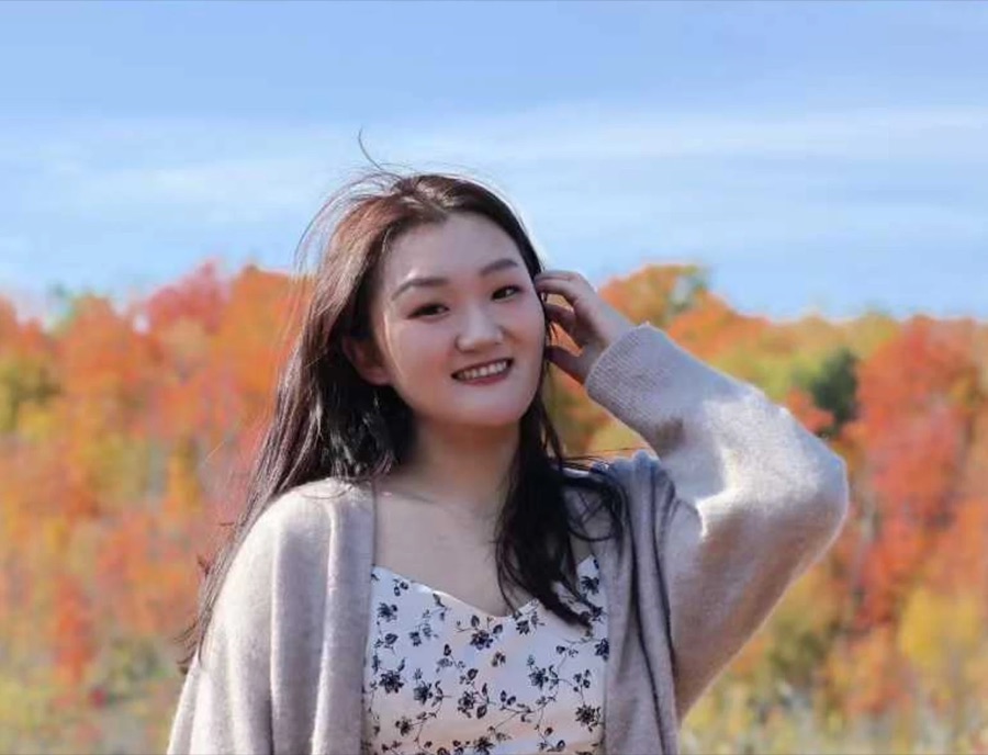 Smiling in front of autumn trees
